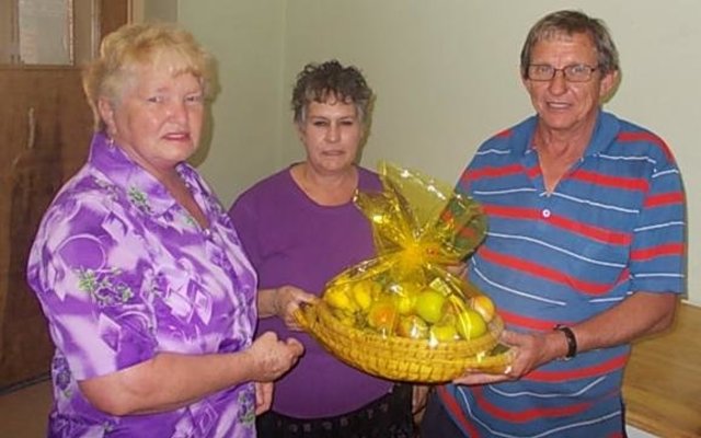 Stienie Geldenhuys oorhandig ‘n vrugtemandjie aan die koshuis-egpaar, Adana en Gerrit Geldenhuys